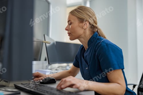 Preview: Nurse on Duty working on computer at the Reception Desk in modern clinic