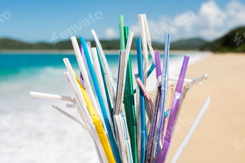Preview: Heap of used plastic straws on background of clean beach and ocean waves. Plastic ocean