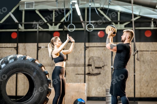 Preview: Young couple training with ball in the gym