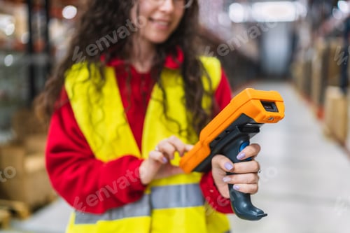 Preview: Female warehouse worker using barcode scanner for inventory management