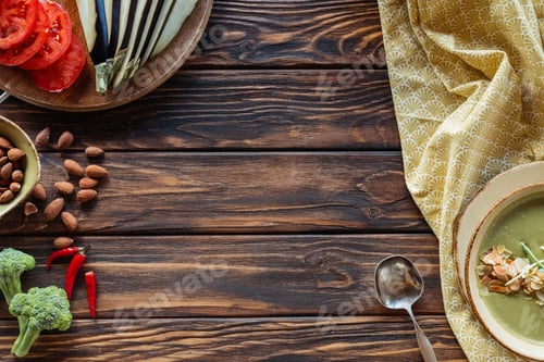 Preview: top view of vegetarian cream soup, fresh vegetables and almonds on wooden surface