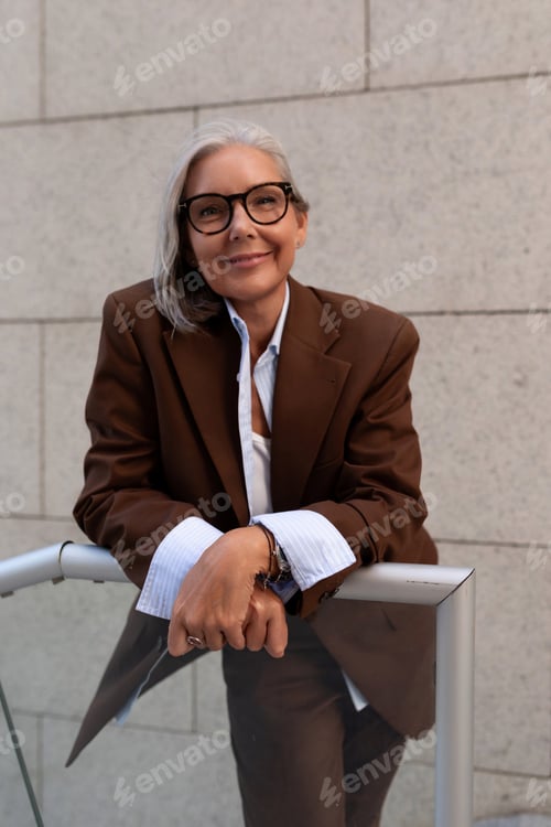 Preview: portrait of a model of a slender gray-haired woman of mature years dressed in an elegant brown suit