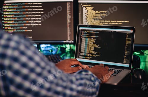 Preview: African American man sitting at a computer developing software through coding