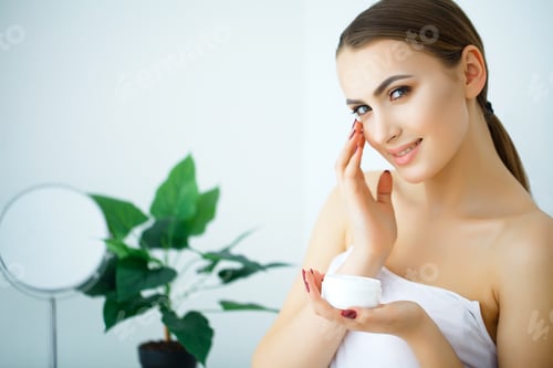 Preview: Woman Applying Moisturizer Cream in Bright Home