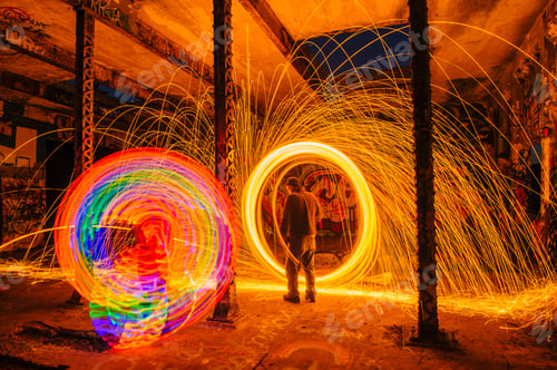 Preview: Man creating multi-color and golden spark light trails in derelict building