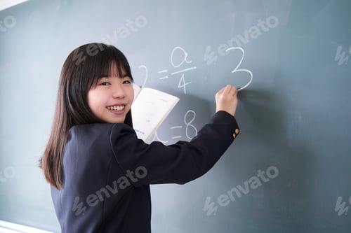 Preview: A Japanese junior high school girl writes on the blackboard in her classroom