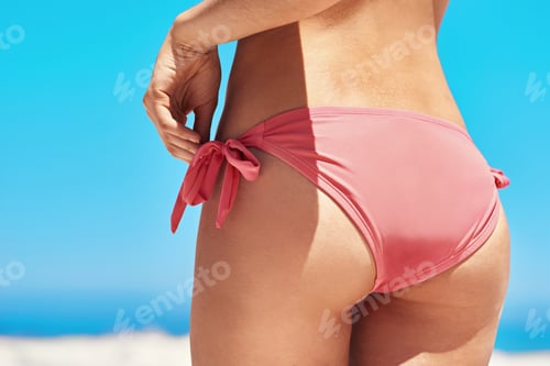 Preview: Bikini bottom. Shot of a sexy young womans buttocks on the beach.
