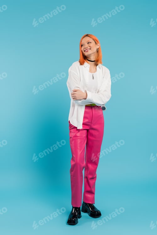 Preview: happy face, cheerful asian young woman with dyed hair standing in casual attire and smiling on blue