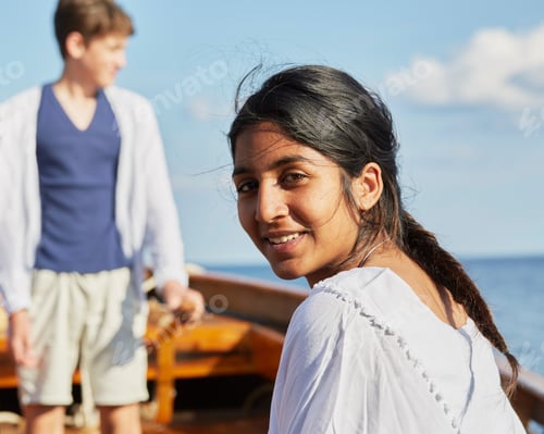 Preview: Woman on boat looking over shoulder at camera smiling