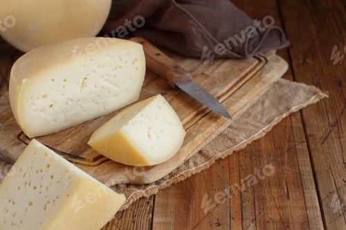 Preview: Pieces of fresh homemade cheese on a wooden board top view