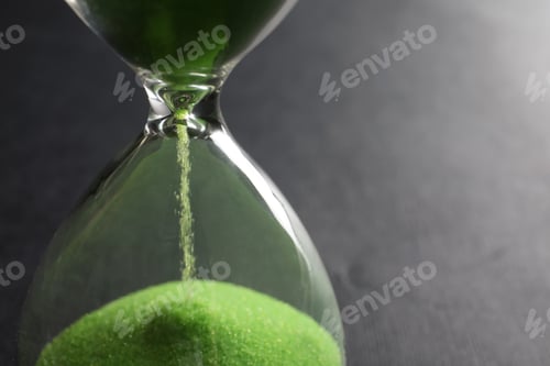Preview: Hourglass with flowing sand on grey background, closeup. Time management