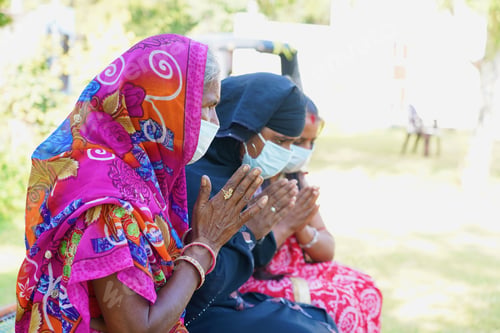 Preview: Closeup of three Indian women in facemasks praying during the coronavirus pandemic
