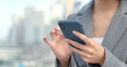 Preview: Business woman look at mobile phone
