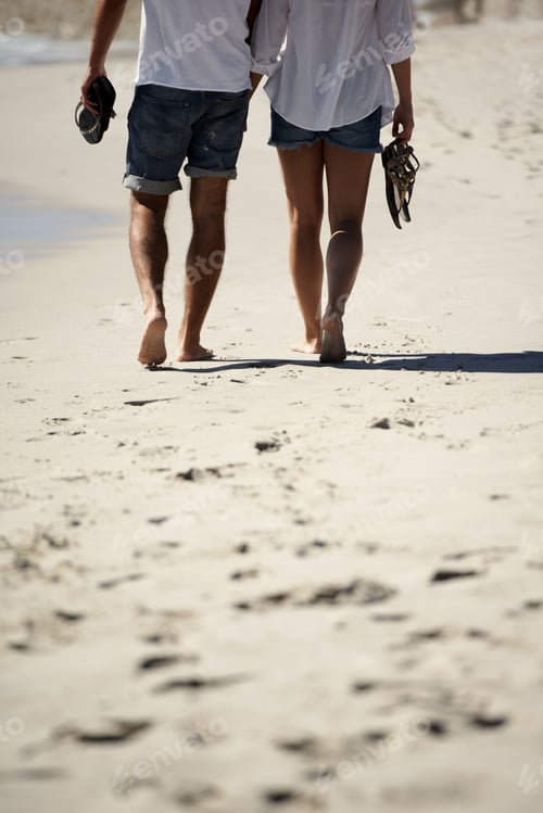 Preview: Seaside stroll. Cropped image of a couple walking on the beach.