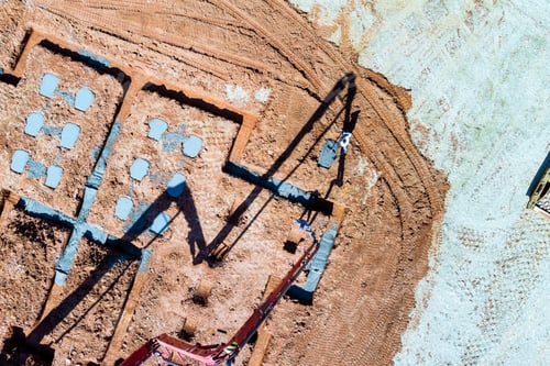 Preview: Using a concrete pump builder is pouring wet concrete into house foundation.
