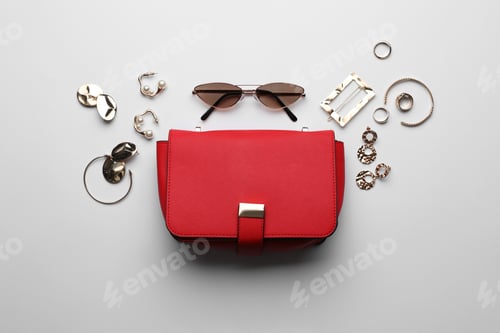 Preview: Stylish woman's bag, sunglasses and bijouterie on light background, flat lay