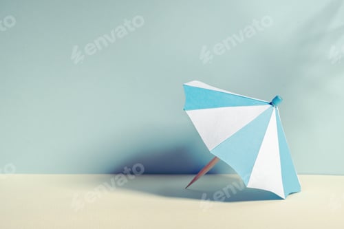 Preview: Beach umbrella with paper on blue background and shadow from palm tree