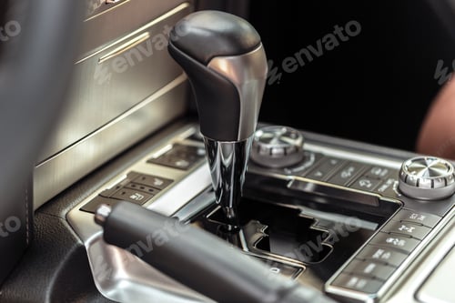 Preview: Gear shift and control buttons inside a car during driving