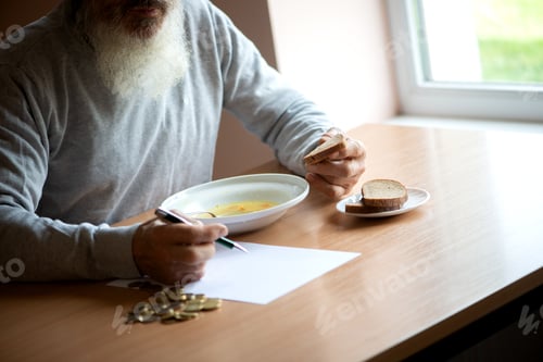 Preview: Sad old man counting money and plans to buy grocery while sitting at an empty soup plate