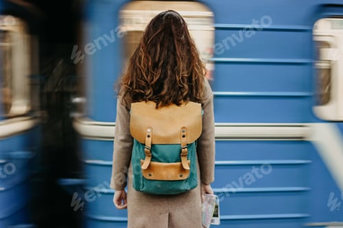 Preview: Young woman curly red head girl traveller with backpack and map in subway station in front of train