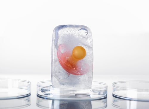 Preview: A vibrant orange marble encased in a clear ice block on a sleek surface with petri dishes.