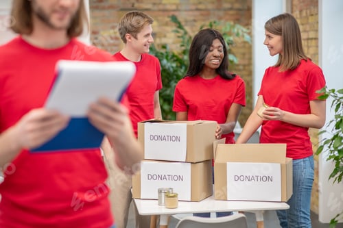 Preview: Young volunteers in red tshirts at work in a distribution point