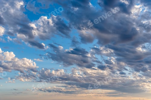 Preview: Beautiful white puffy clouds against blue sky during dramatic sunset