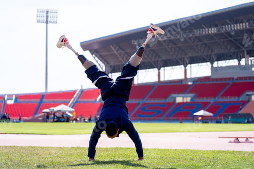 Preview: Asian para-athletes with prosthetic blades sprint on a running track at stadium.