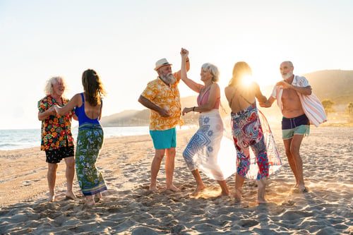 Preview: Happy group of senior friends bonding at the beach during summertime