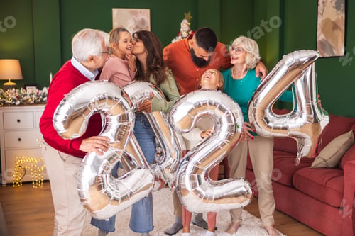 Preview: Family holding giant balloons shaped as numbers 2024 while having New Year party