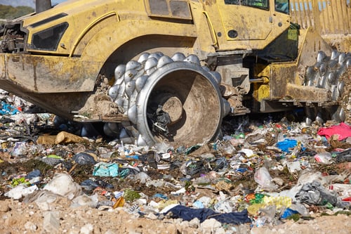 Preview: Heavy machinery shredding garbage in an open air landfill. Pollution management