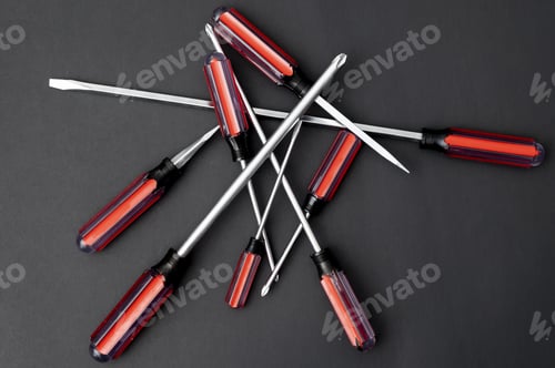 Preview: Top view of screwdrivers of different sizes on a black background