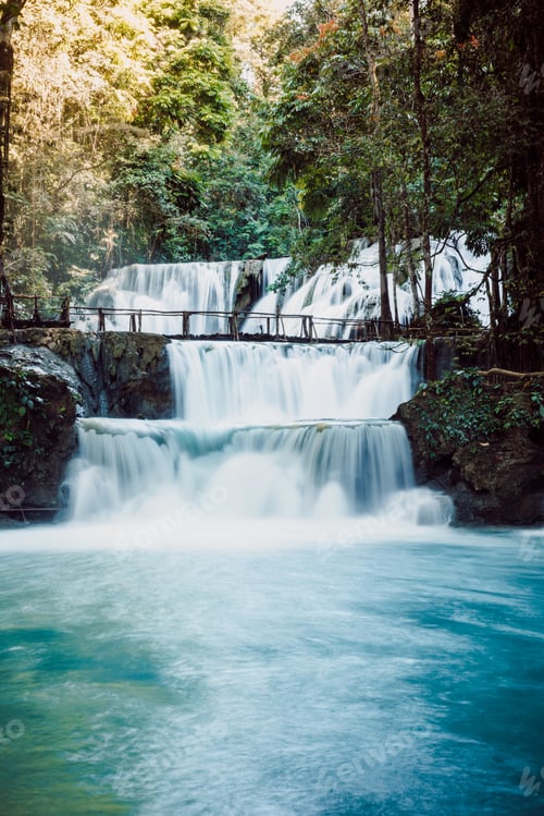 Preview: Cascade waterfalls with blue water and wooden bridge in Sulawesi