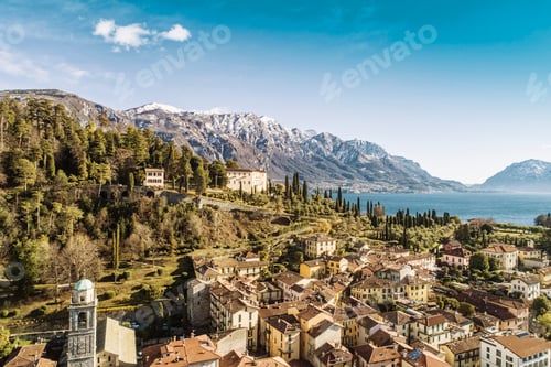Preview: Aerial view of Bellagio village on Como lake with blue sky and the Alps in the background