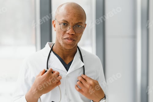 Preview: African American man male hospital doctor in white coat with stethoscope.