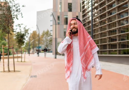 Preview: Arab man speaking on smartphone on street