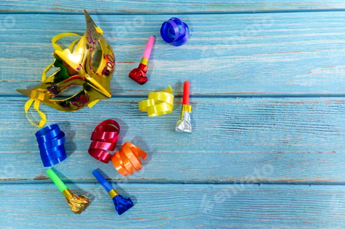 Preview: Carnival mask and party blowers on blue wood