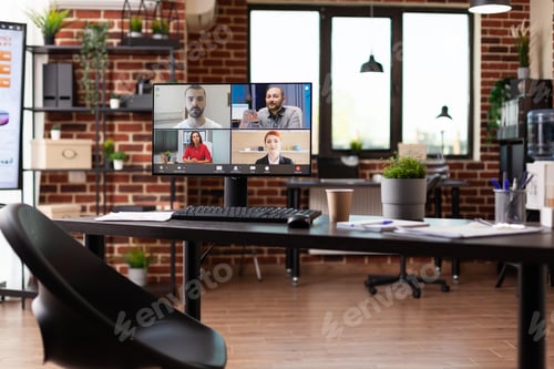 Preview: Computer with video call conference on desk in empty office