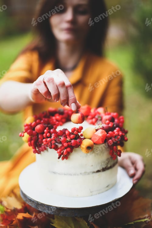 Woman Holding Cake Decorated with Fruit in Garden