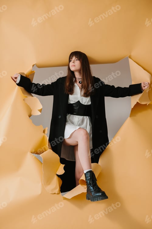 Preview: Portrait of a stylish girl on a torn studio background.
