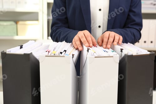 Preview: Woman taking documents from folder in archive, closeup
