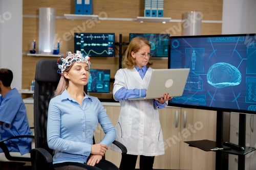 Preview: Doctor analyzing live data on a laptop during a girl's brain scan procedure