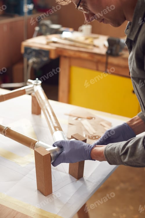 Preview: Close Up Of Male Craftsman In Workshop Assembling Hand Built Sustainable Bamboo Bicycle Frame