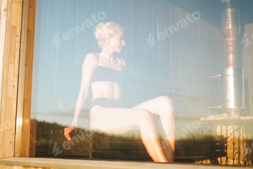 Preview: Young woman lies on wooden shelf in spa sauna, treat yourself
