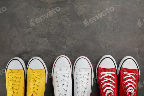 Preview: Different stylish sneakers on grey stone table, flat lay. Space for text