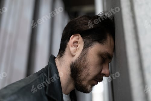 Preview: close-up portrait of a sad man suffering from depression and migraine