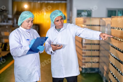 Preview: In warehouse quality control team checking drinking bottle stack on pallet before delivery