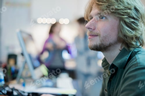 Preview: A man looking up from his task in a computer repair shop.