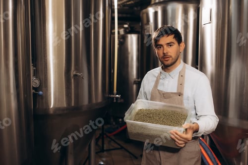 Preview: A male brewer holding a box of hops