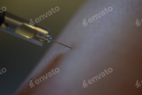 Preview: Selective focus shot of an injection into the arm